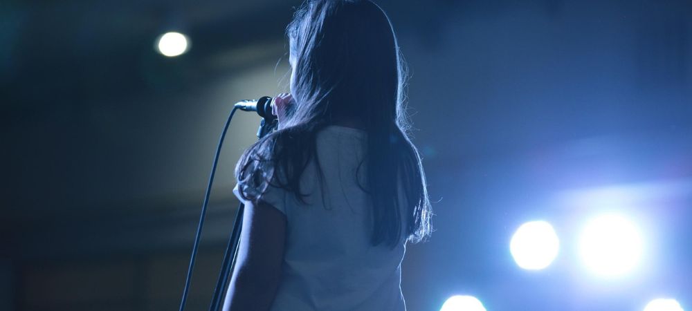 A child practicing public speaking on stage