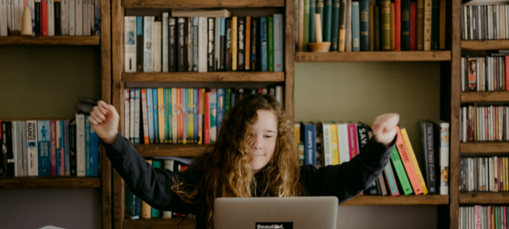 Grade 9 child in front of a laptop, in her study room, celebrating subject choices